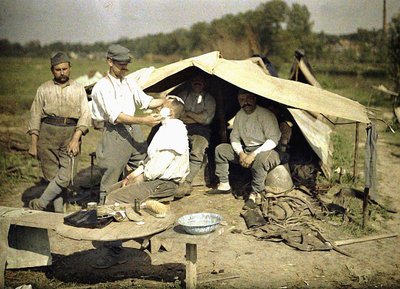 Soldat wird von einem Barbier in einem französischen Militärlager rasiert, Soissons, Aisne, Frankreich, 1917 von Fernand Cuville